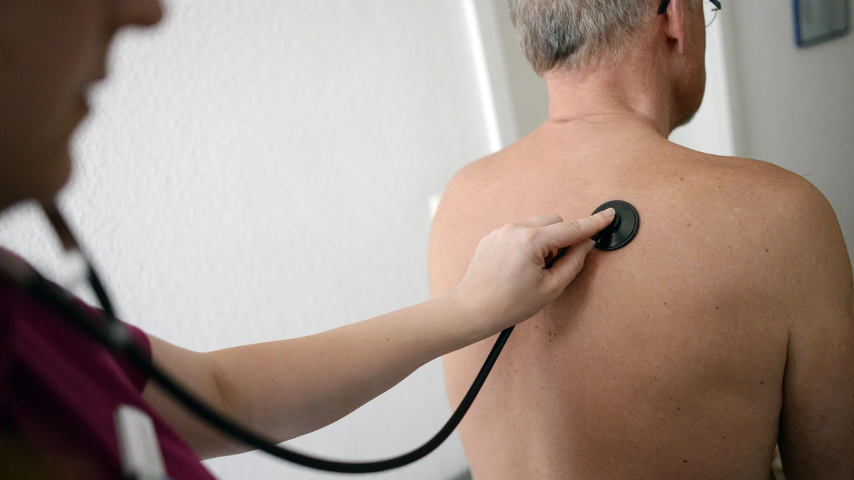 Behandlungen sind teuer: Eine Medizinerin untersucht einen Patienten mit einem Stethoskop. (Symbolbild)