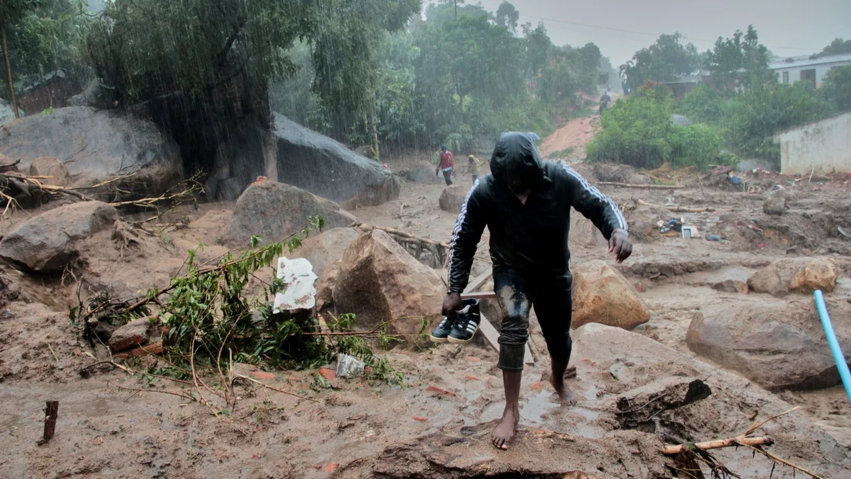 Ein Mann in Malawi kämpft sich durch den Unrat, den Zyklon „Freddy“ angespült hat.