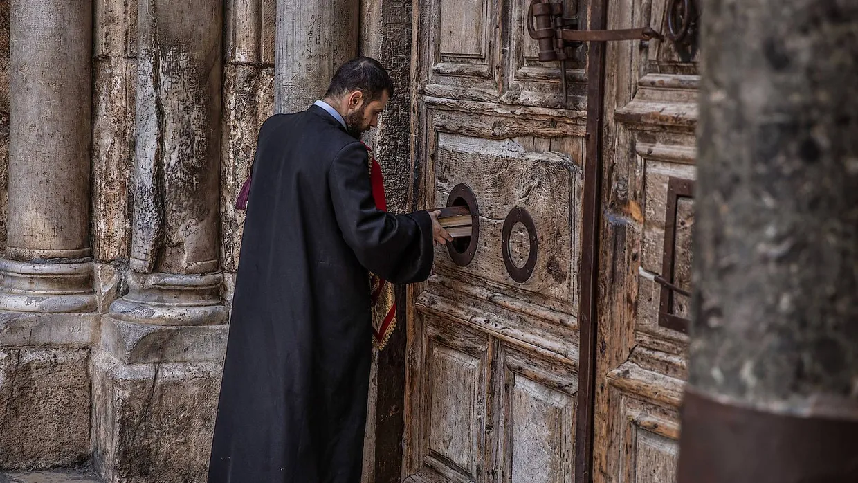 Ist die Tür noch geschlossen oder bereits einen Spalt geöffnet? Ein armenischer Priester an der Grabeskirche in Jerusalem
