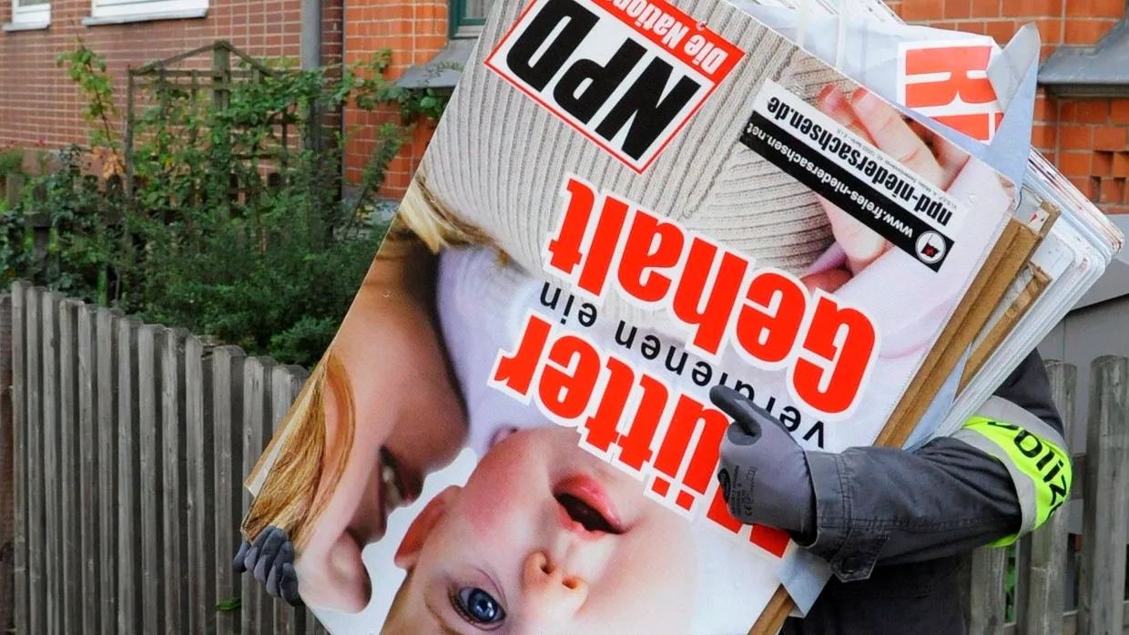 Polizeibeamte tragen NPD-Plakate aus der Wohnung eines Mitglieds von „Besseres Hannover“