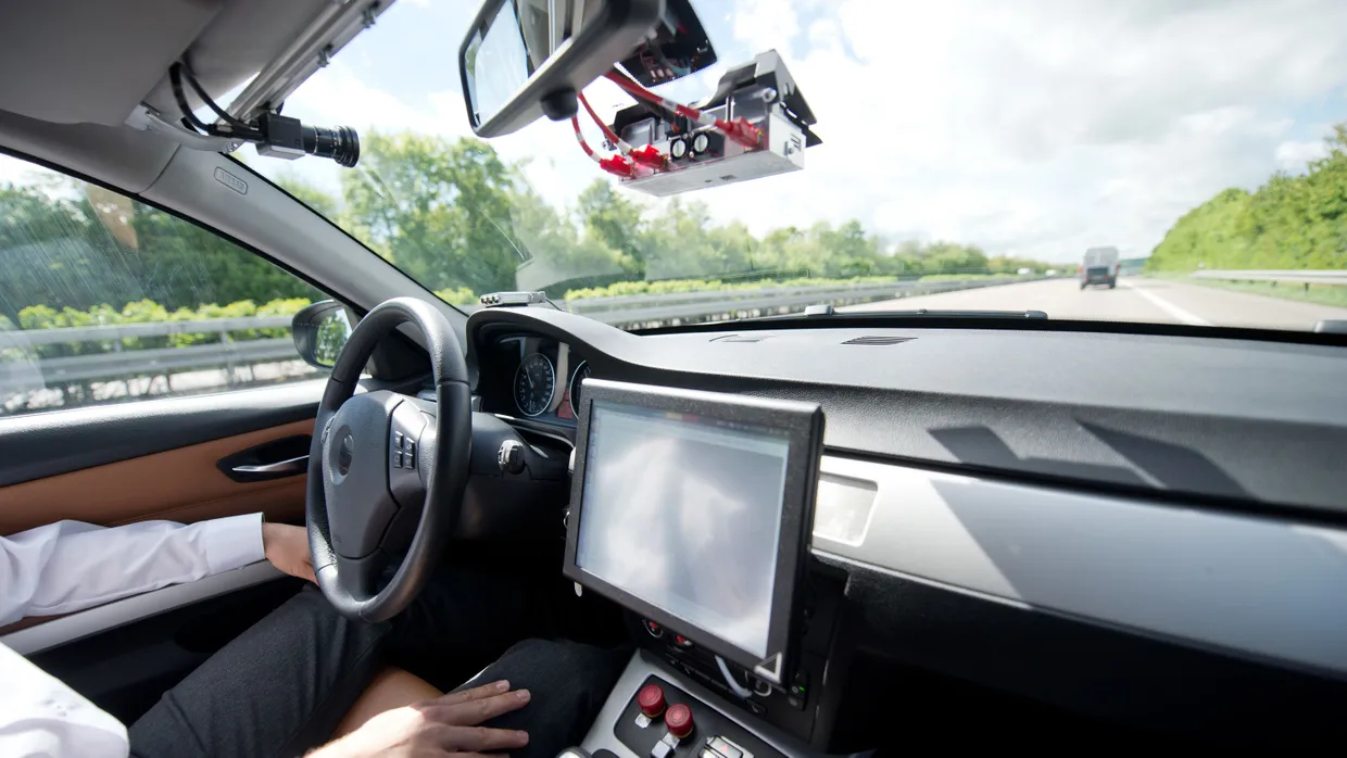 Ein Mitarbeiter eines Automobilherstellers wertet Daten während einer Fahrt auf der Autobahn aus.