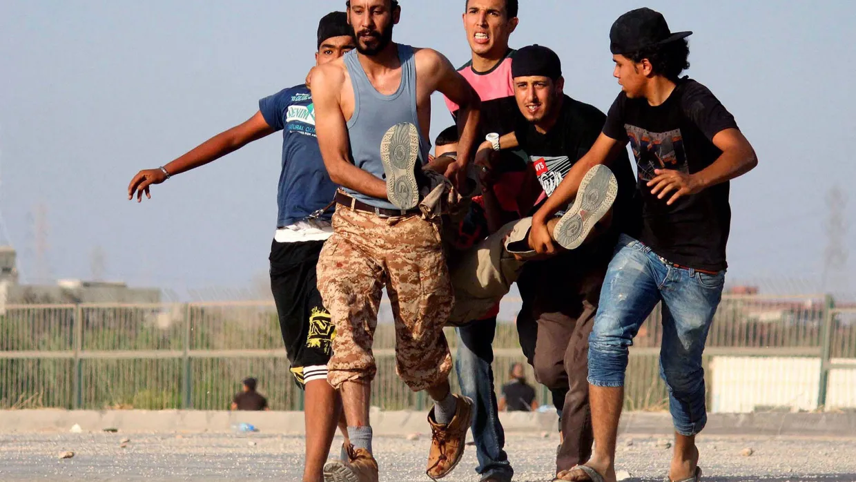 Kämpfe in Benghazi: Eine Gruppe junger Libyer trägt einen Verletzten aus der Gefahrenzone