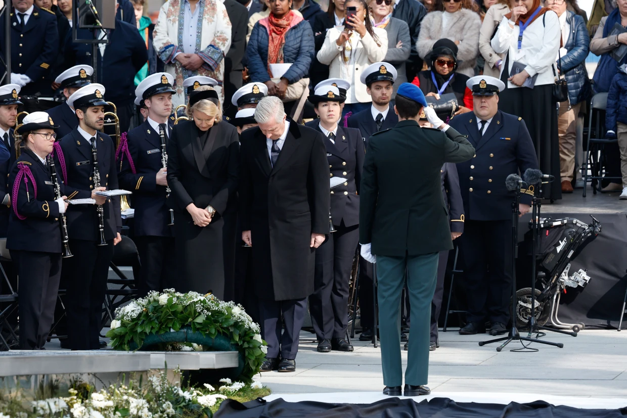 König Philippe und Königin Mathilde senken ihre Köpfe nach der Kranzniederlegung.