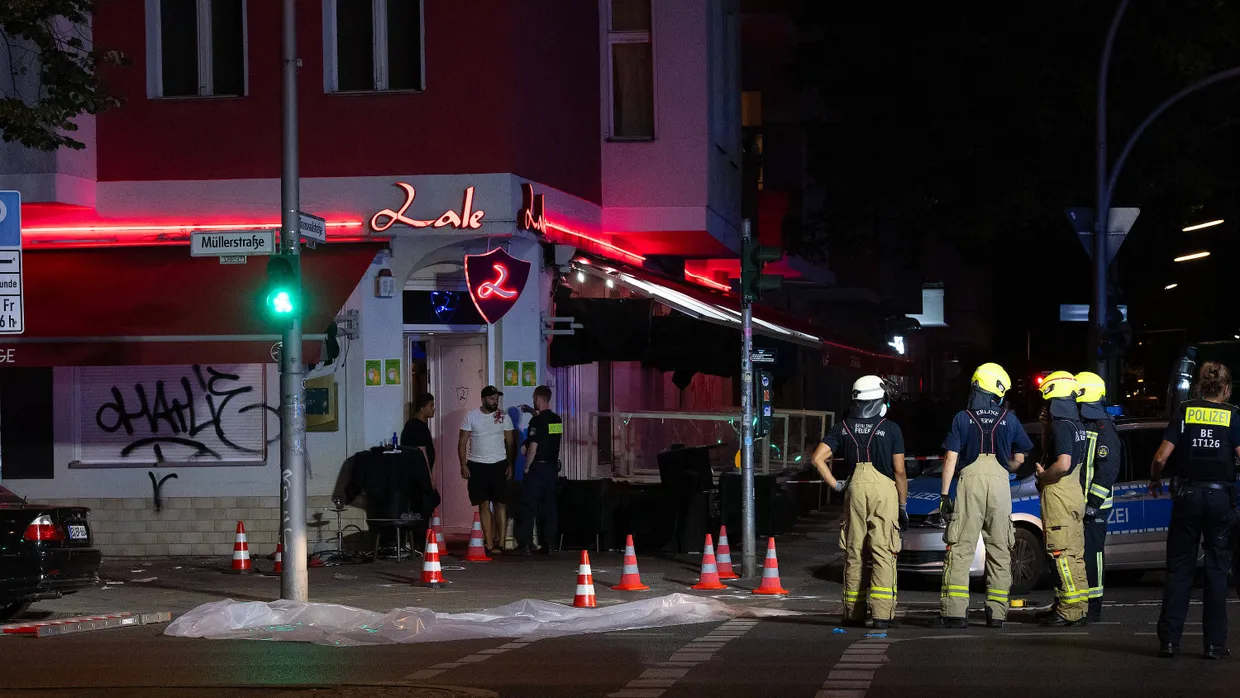 Feuerwehrleute stehen vor einem Lokal in der Müllerstraße in Berlin-Wedding in der Nacht von Sonntag auf Montag.