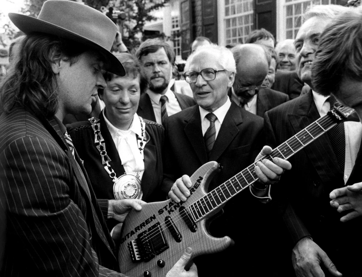 1987:  Udo Lindenberg überreicht dem SED-Generalsekretär Erich Honecker eine Gitarre mit der Aufschrift „Gitarren statt Knarren“.