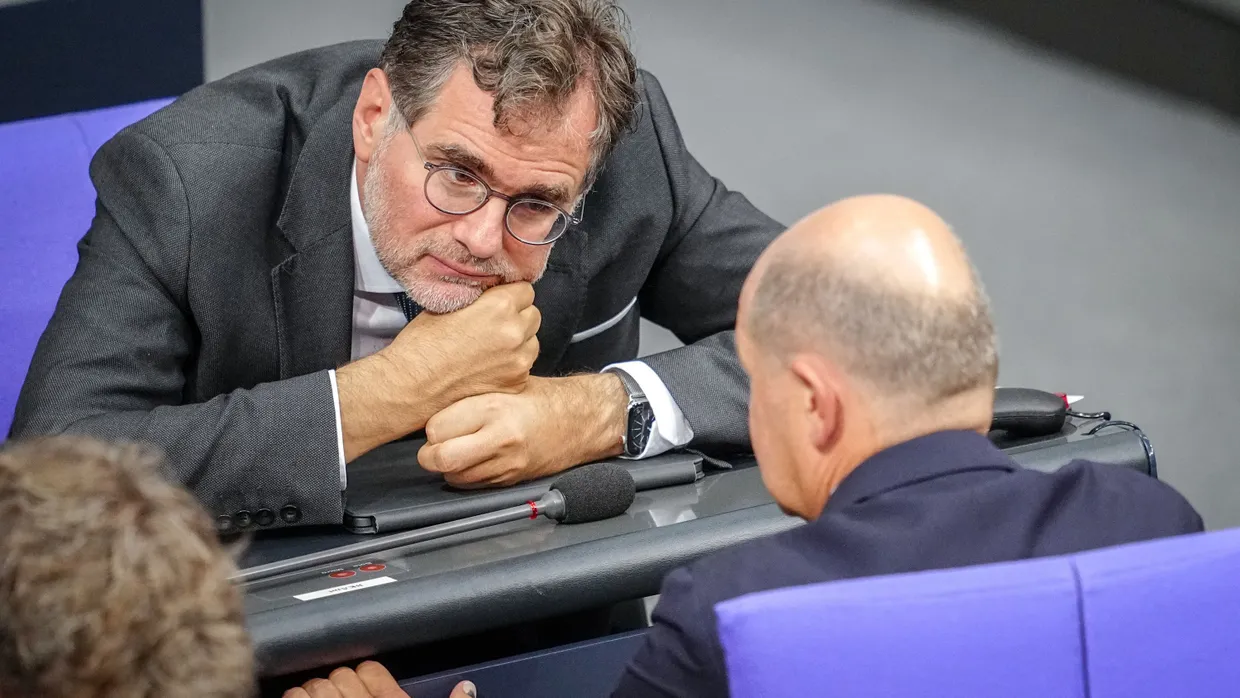 Bundeskanzler Olaf Scholz (SPD) spricht in der Generaldebatte um den Haushalt 2025 im Bundestag mit Wolfgang Schmidt (SPD), dem Minister für besondere Aufgaben.
