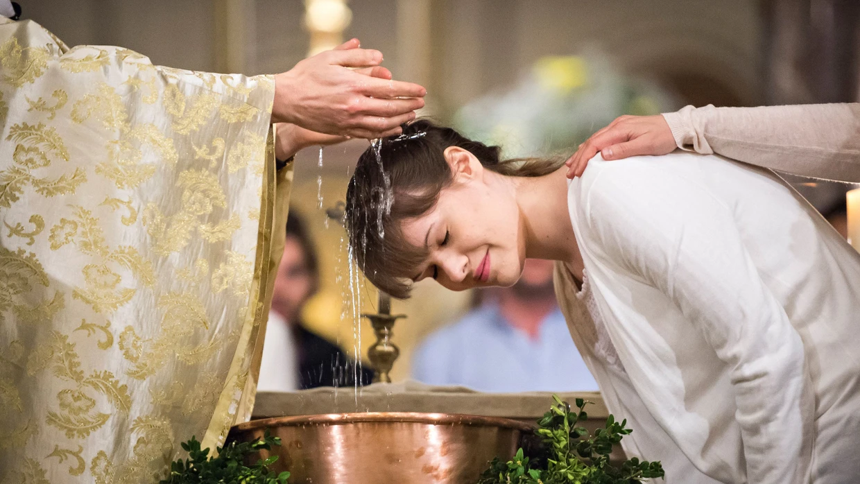 Eine junge Frau lässt sich in Paris katholisch taufen. In Frankreich ist der Anstieg der Erwachsenentaufen noch einmal deutlich höher als in Deutschland.