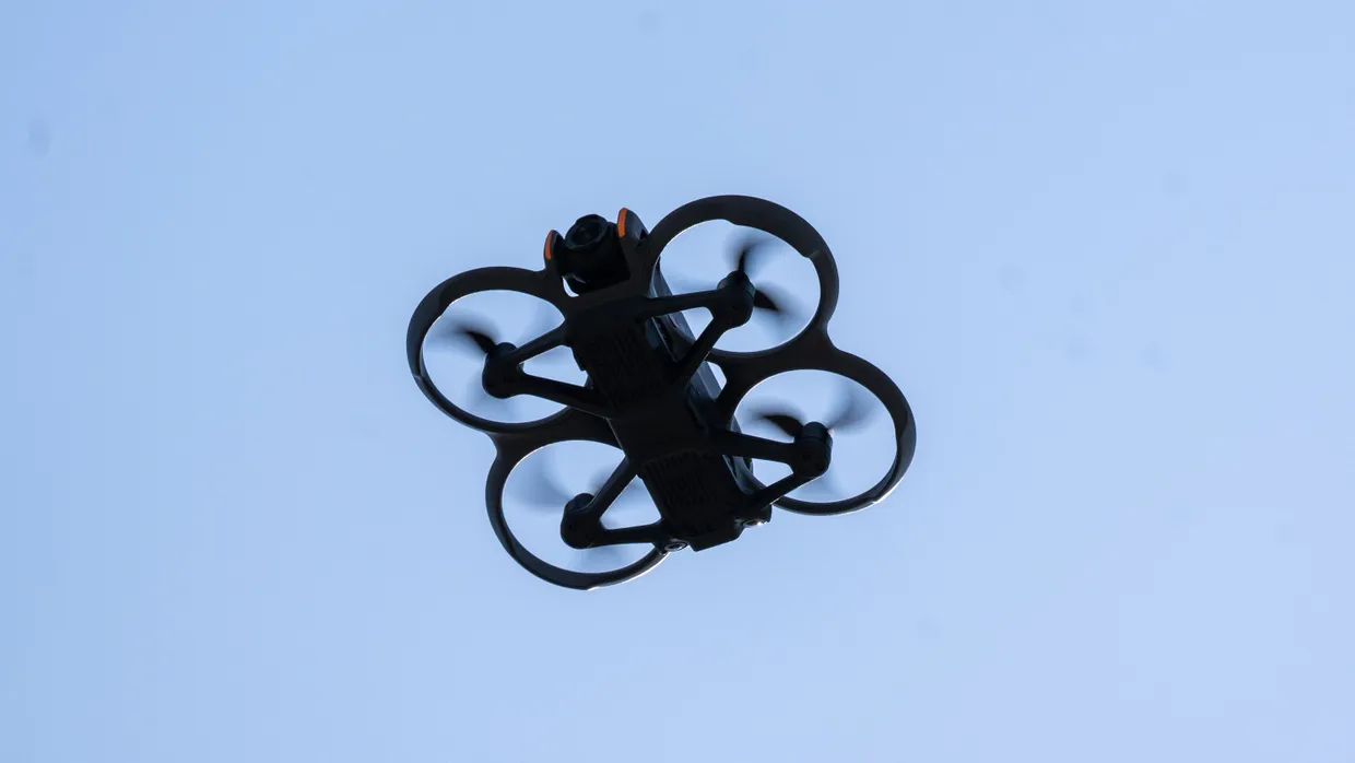 Eine Drohne mit einer Kamera fliegt durch die Luft.