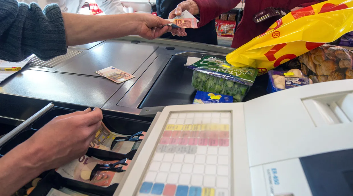 Eine Frau bezahlt ihren Einkauf an einer Supermarktkasse in einem Lebensmittelmarkt in Straubing (Bayern).