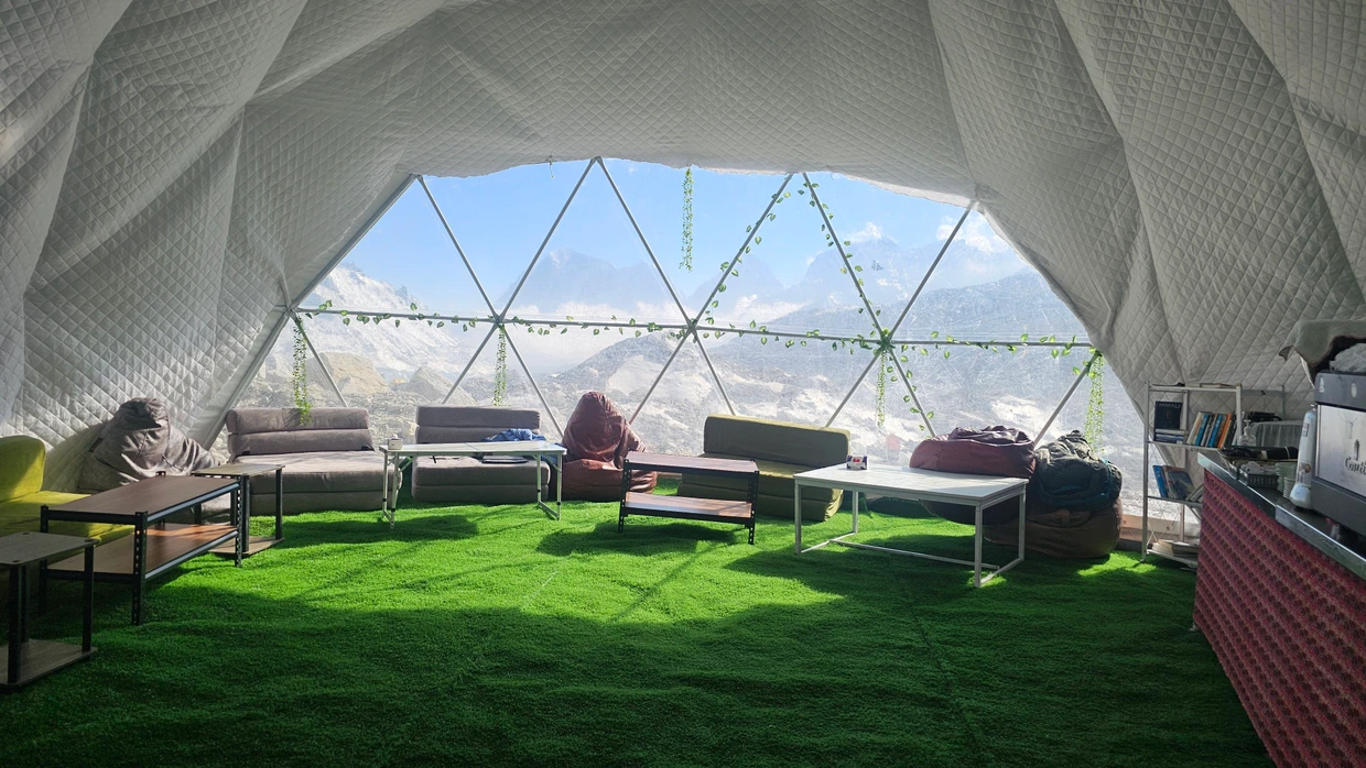 Kunstrasen auf dem Boden, bequeme Sitzgelegenheiten, eine (derzeit kaputte) Siebträgermaschine: Der Ausblick im Café des Basislagers ist gewaltig.