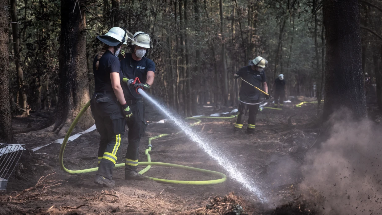 Feuerwehrmänner bei Nachlöscharbeiten im Hürtgenwald.