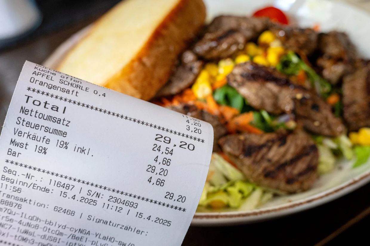 Bald nur noch 7 Prozent: Eine Rechnung mit Mehrwertsteuer neben einem vollen Teller in einem Restaurant.