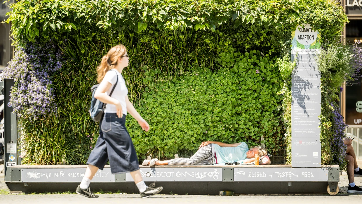 Begehrter Schattenplatz: Eine Frau sucht auf dem Frankfurter Roßmarkt Schutz vor der Sonne.