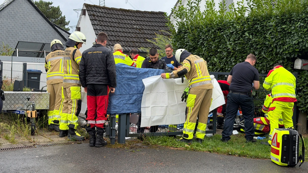 Einsatzkräfte stehen an einem Grundstück.