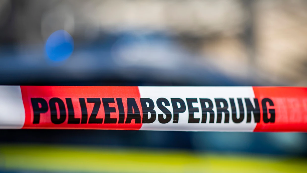 Ein Absperrband mit der Aufschrift «Polizeiabsperrung» ist vor einem Polizeiwagen aufgespannt. (Symbolbild)