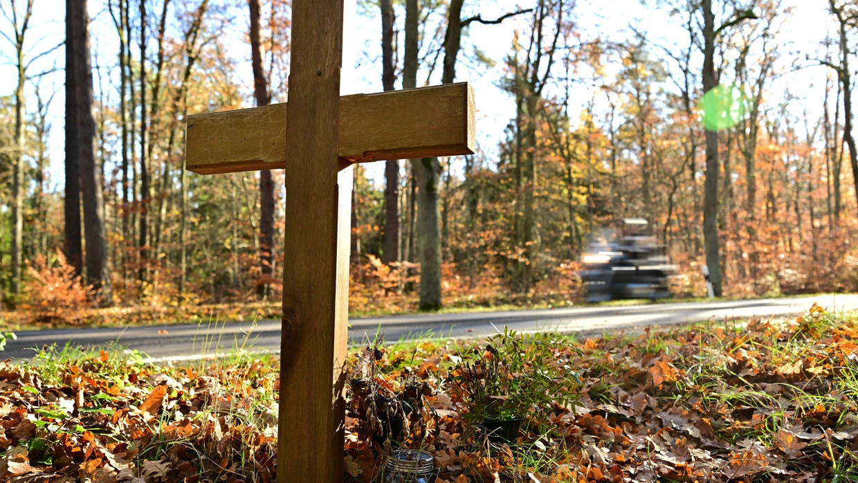 Ein Kreuz für eine Verkehrstote steht am Rand einer Straße.