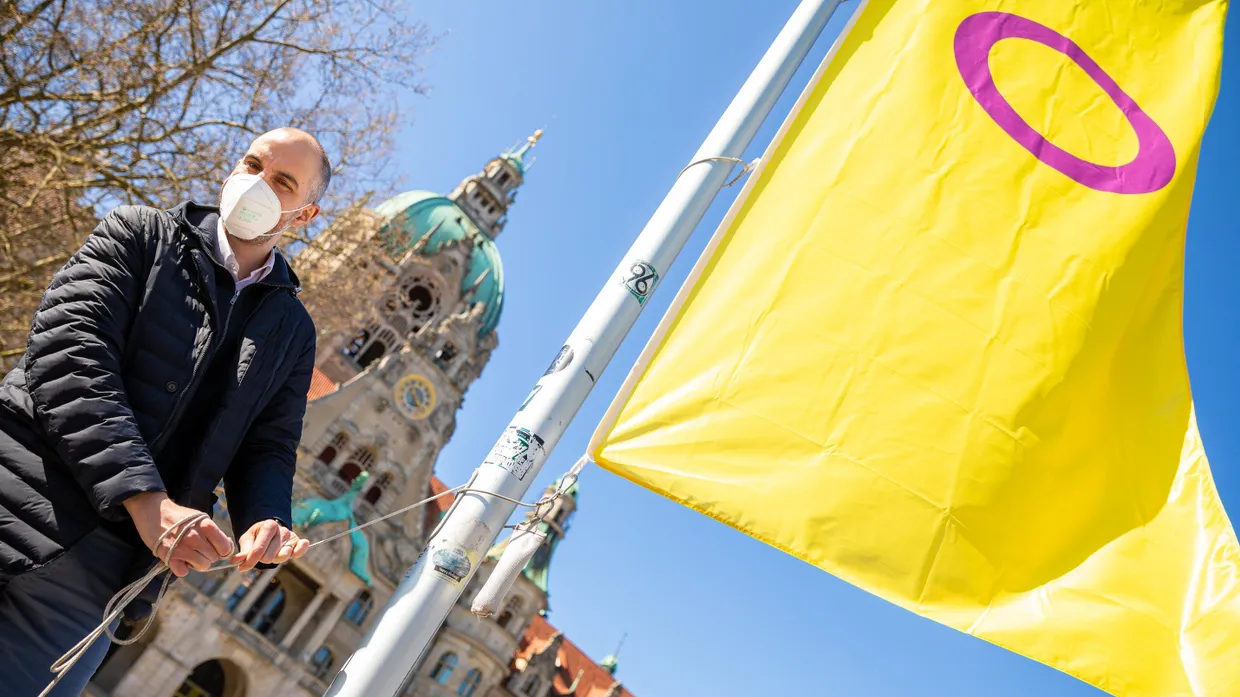 Belit Onay, Oberbürgermeister von Hannover, hisst vor dem Neuen Rathaus eine Inter* Pride Flagge.