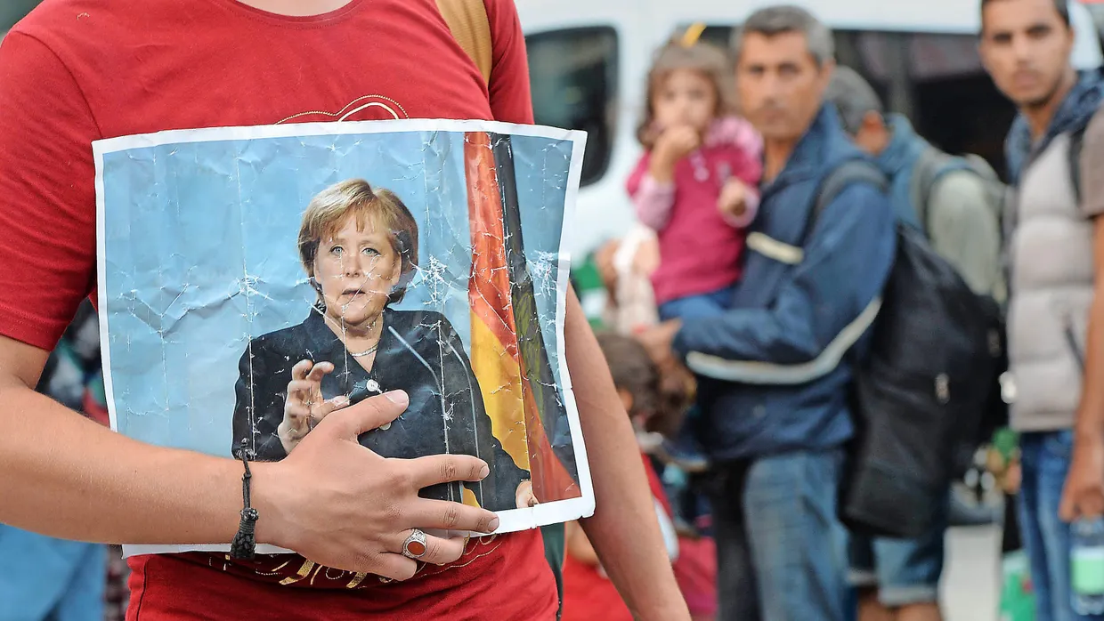 Ein Flüchtling mit einem Bild Angela Merkels am 5. September 2015 in München