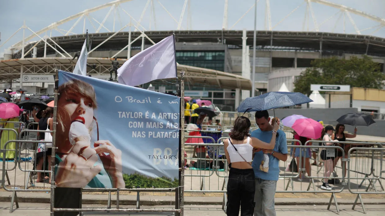 Ein Paar schützt sich vor einem Taylor-Swift-Konzert in Rio de Janeiro mit einem Schirm vor der Hitze.