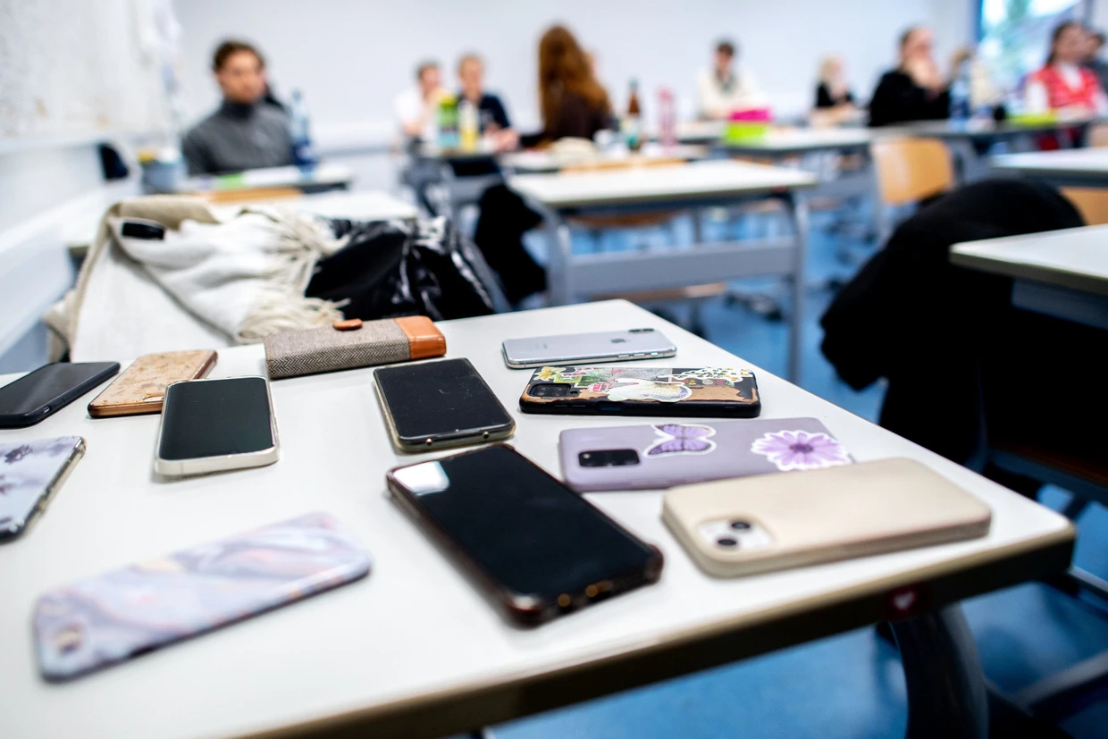 Zahlreiche Smartphones der Schülerinnen und Schüler liegen auf einem Tisch in der Graf-Anton-Günther-Schule (GAG).