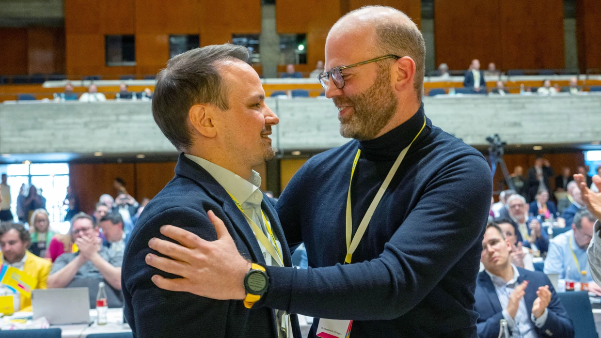 Der neue Landesvorsitzende Matthias Fischbach  umarmt beim Landesparteitag der FDP Bayern im Stadttheater den Generalsekretär Daniel Kuhagen.