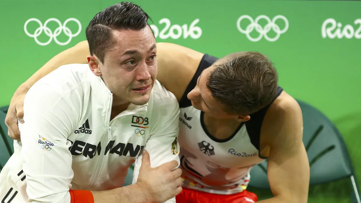 Andreas Toba (links) verletzt sich schwer, turnt aber für das Team weiter.