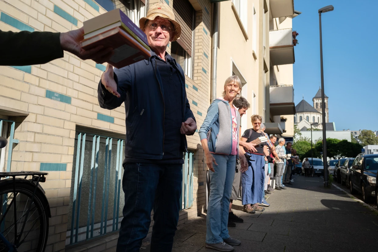 Nachbarschaftsbuchhandlung: Kunden und Anwohner halfen dem Buchladen „Land in Sicht“ im September 2024 mit einer Bücherkette beim Umzug im Nordend.