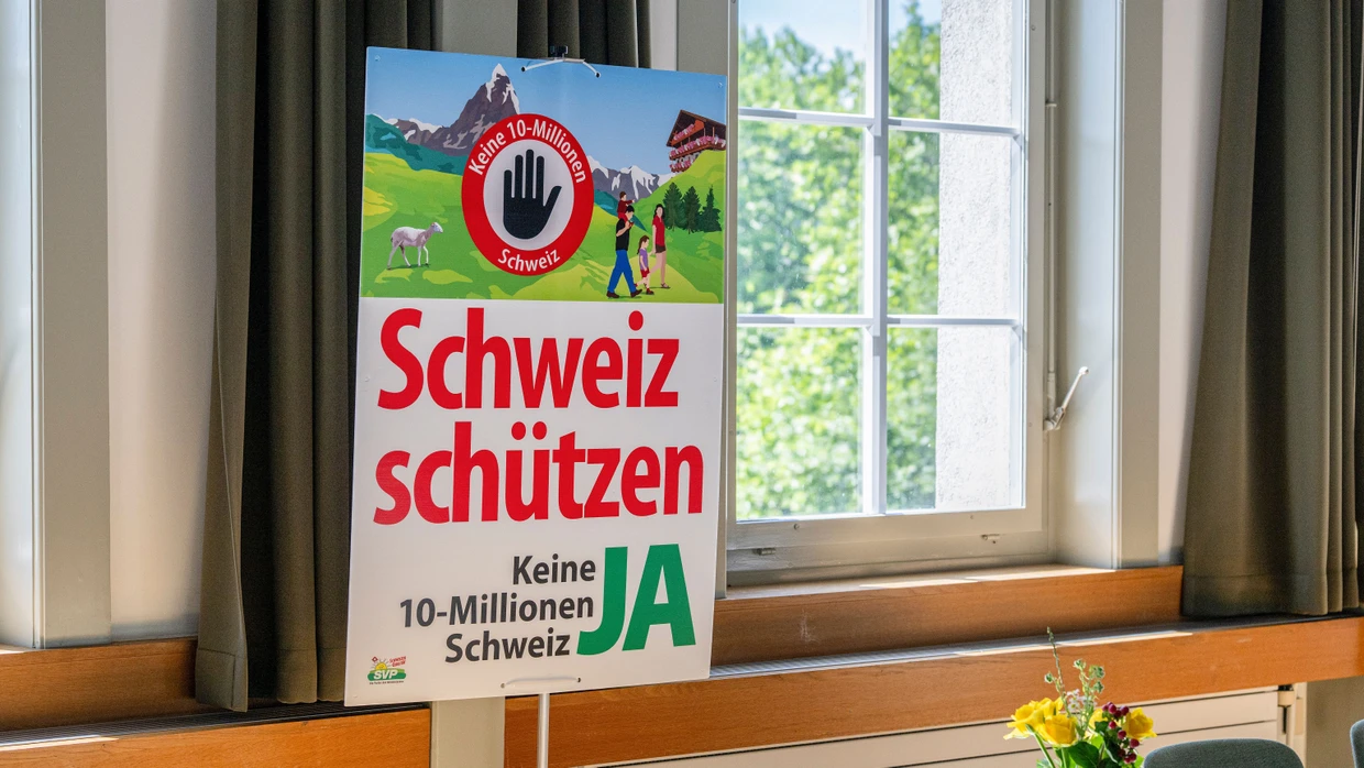 Ein Abstimmungsplakat in Aarberg bei einem Abstimmungsstand für die Volksinitiative „Keine 10-Millionen-Schweiz“