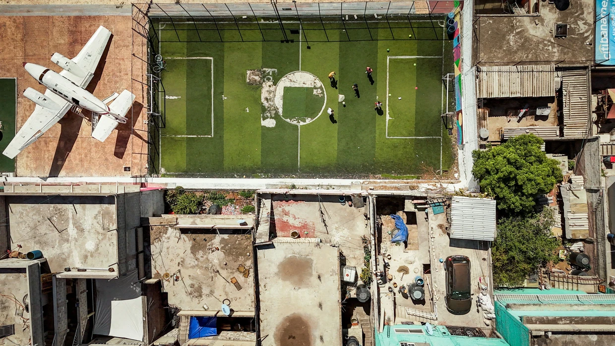 Ein Fußballplatz, ein Flugzeugrumpf und ringsherum dichtes Häusermeer: Der Avioneta-Park in Ecatepec, einer der am dichtesten besiedelten Gemeinden im Großraum Mexiko-Stadt, aus der Vogelperspektive.