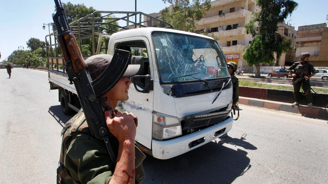 Ein Regierungssoldat neben einem Lastwagen der syrischen Armee, der von der Bombe getroffen wurde.