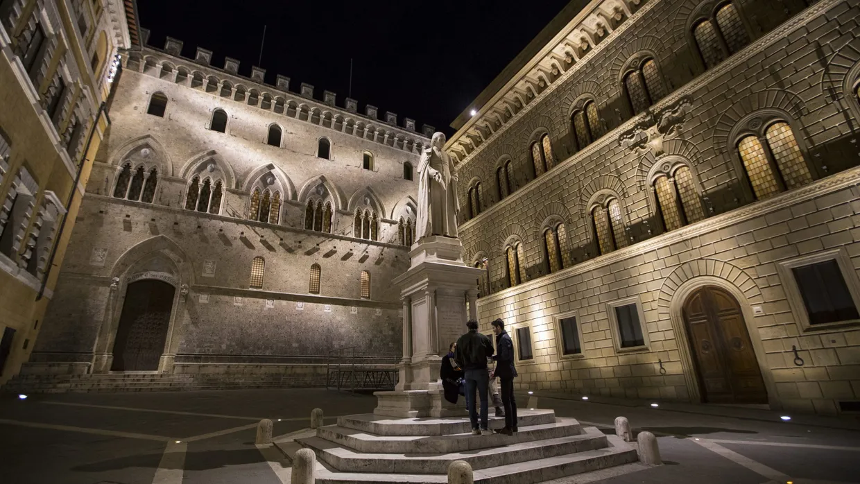 Menschen unterhalten sich am Sallustio Bandini-Monument vor der Zentrale der italienischen Krisenbank Monte dei Paschi di Siena.