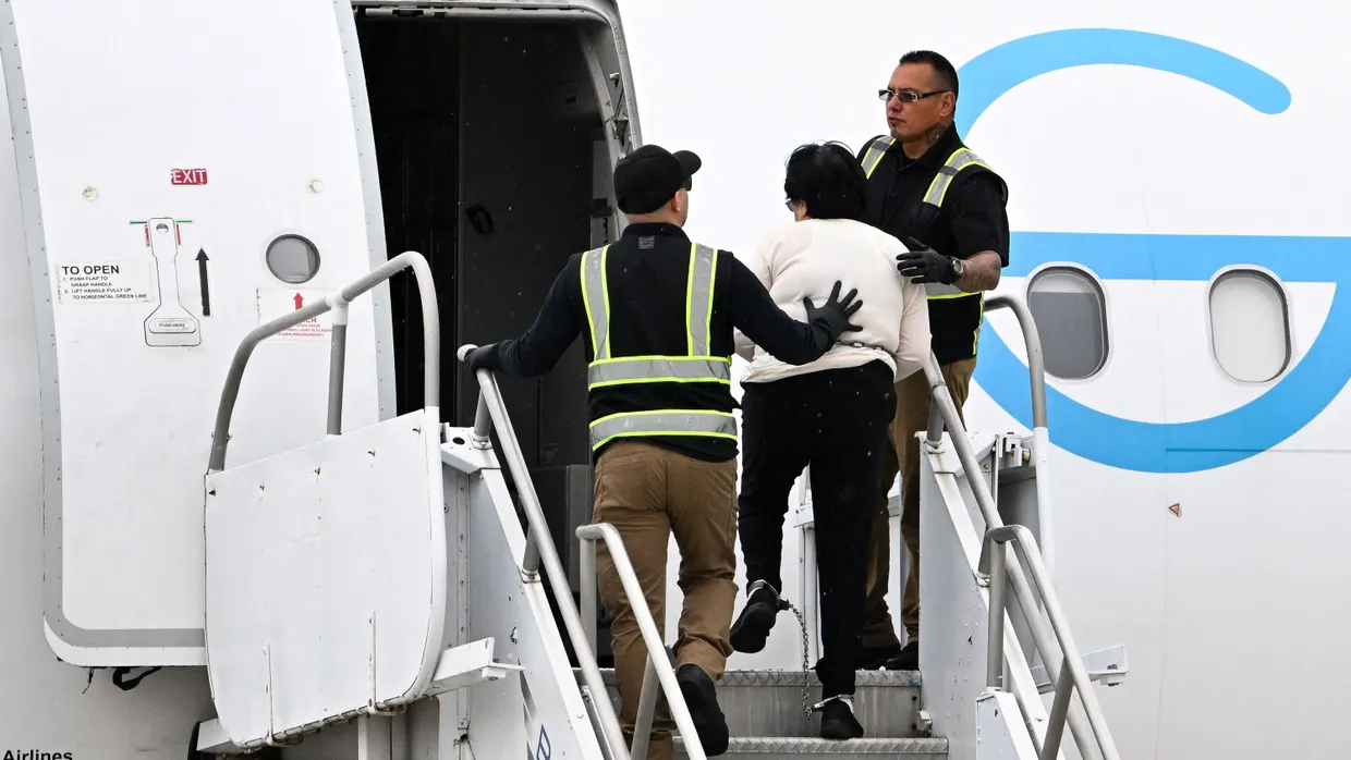 Amerikanische Beamte führen im Juni eine Migrantin in ein Abschiebeflugzeug.