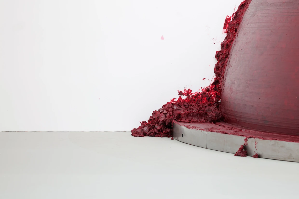 Auch in Duisburg quält sich wie so oft bei dem Bildhauer blutrotes Wachs aus dem Nichts der Wand und versinkt wieder in dieser: Detail aus Anish Kapoors meterhohem Werk „Past, Present, Future", in dem ein mechanischer Arm als Hebamme dient