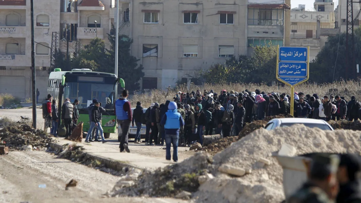 Warten in Homs: Beobachter der Vereinten Nationen steigen unter den Augen von Rebellen in Busse, die sie aus der Kampfzone bringen sollen.