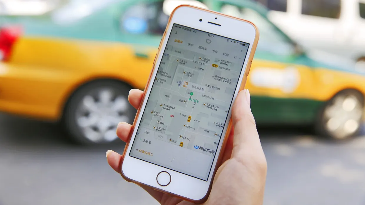 Die chinesische Alternative zu Uber: Ein Mann blickt im Pekinger Straßenverkehr auf die Didi-App.