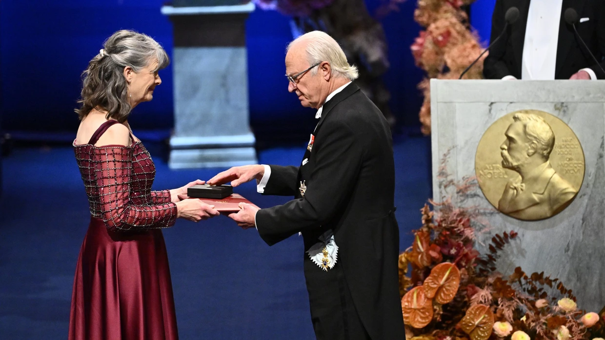 10.12.2025, Schweden, Stockholm: Die Nobelpreisträgerin für Physiologie oder Medizin Mary E. Brunkow erhält ihren Preis von König Carl Gustaf (r) bei der Nobelpreisverleihung in der Stockholmer Konzerthalle.
