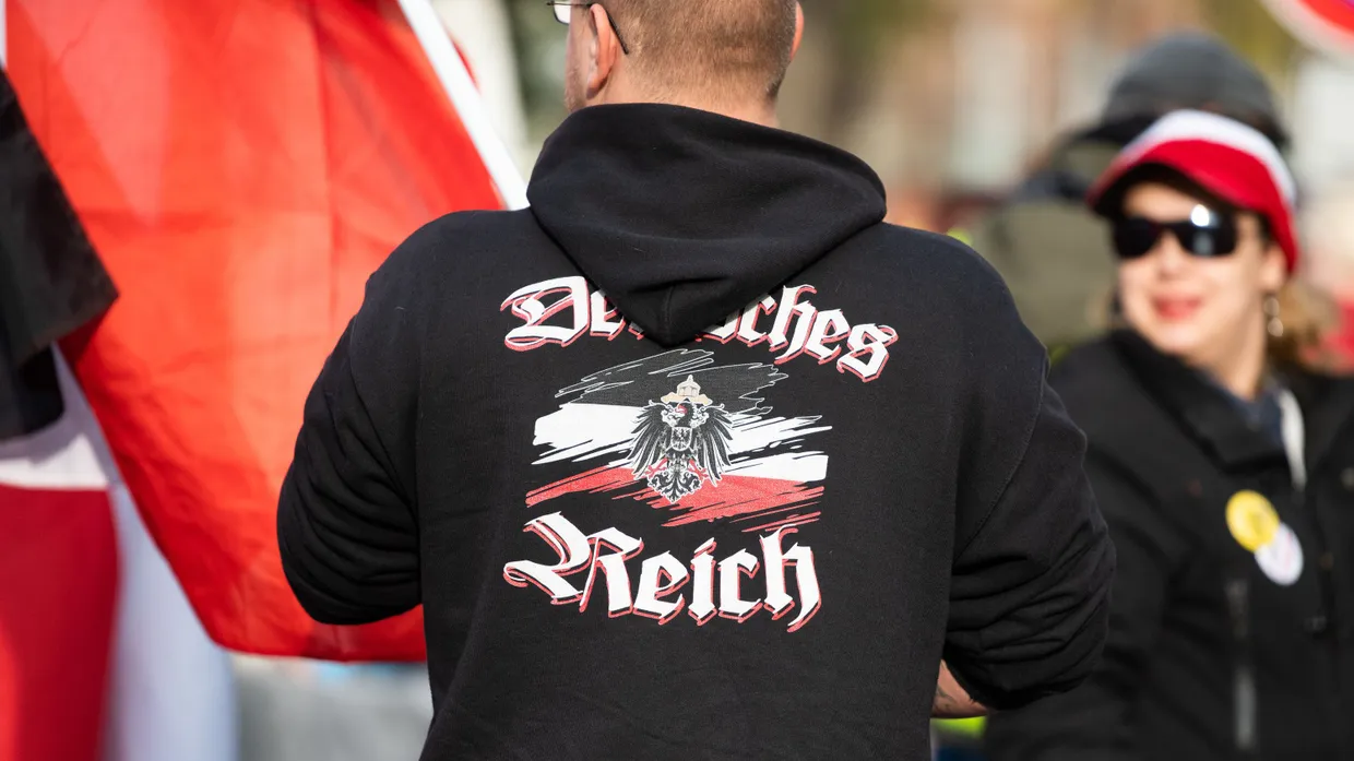 Ein Mann trägt einen Pullover mit dem Aufdruck „Deutsches Reich“ bei einer Demonstration von Reichsbürgern in Potsdam, Brandenburg.