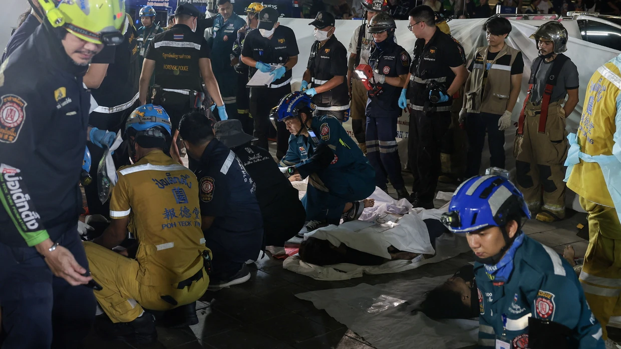 Rettungskräfte sind am Ort eines tödlichen Brandes in einem Lokal in Bangkok, Thailand, im Einsatz und kümmern sich um die Opfer.