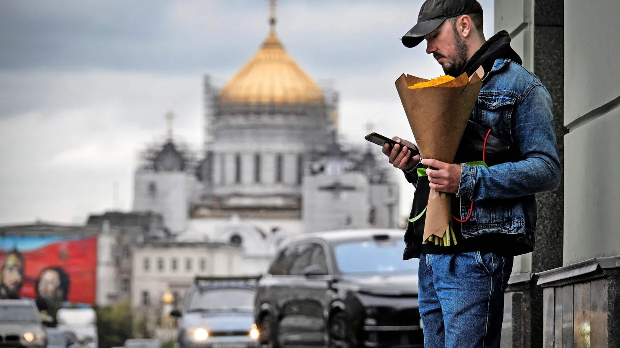 Wer liest mit? Ein Mann mit seinem Smartphone vor der Christ-Erlöser-Kathedrale in Moskau
