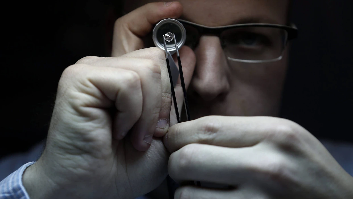 Ein Mann untersucht in der israelischen Diamantenbörse einen Stein.