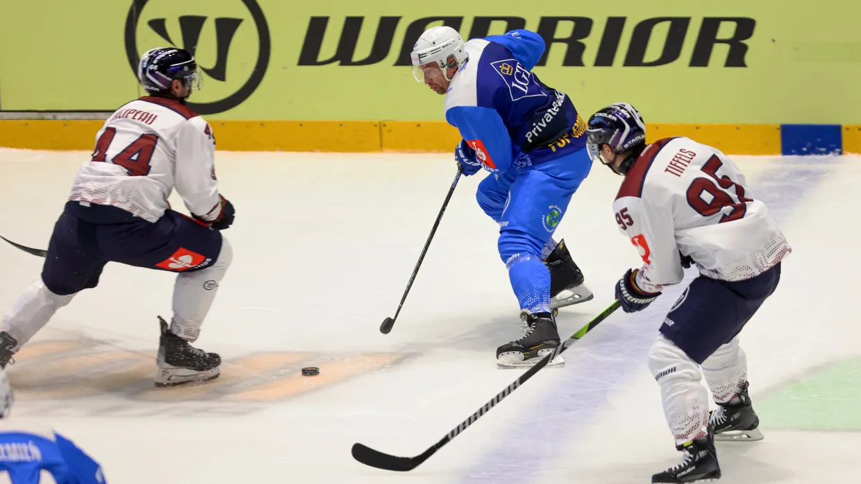 Krystian Dziubinski (M) von Re-Plast Unia Oswiecim und Olivier Galipeau (l) und Frederik Tiffels (r) von Eisbären Berlin in Aktion.