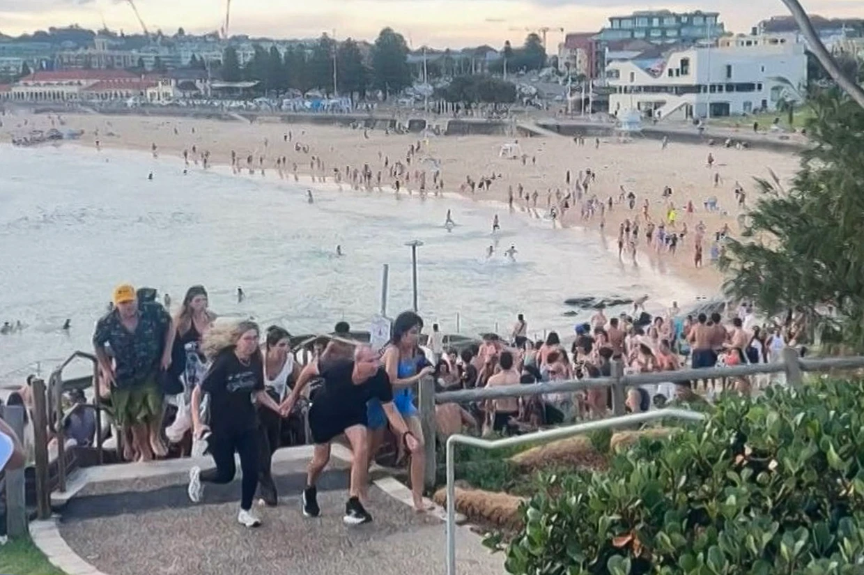 Das Standbild aus einem Video zeigt fliehende Strandbesucher am Sonntag am Bondi Beach