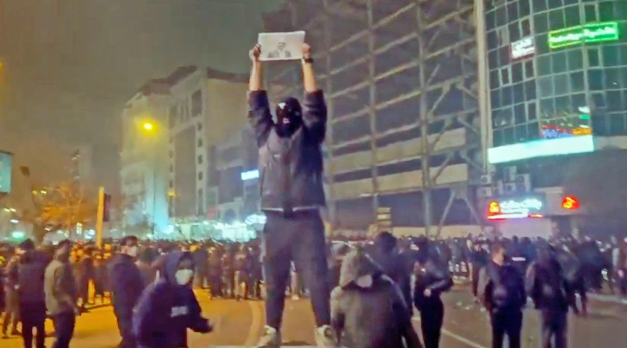 Ein Screenshot  aus sozialen Medien zeigt vermummte Demonstranten am Freitagabend in Teheran.
