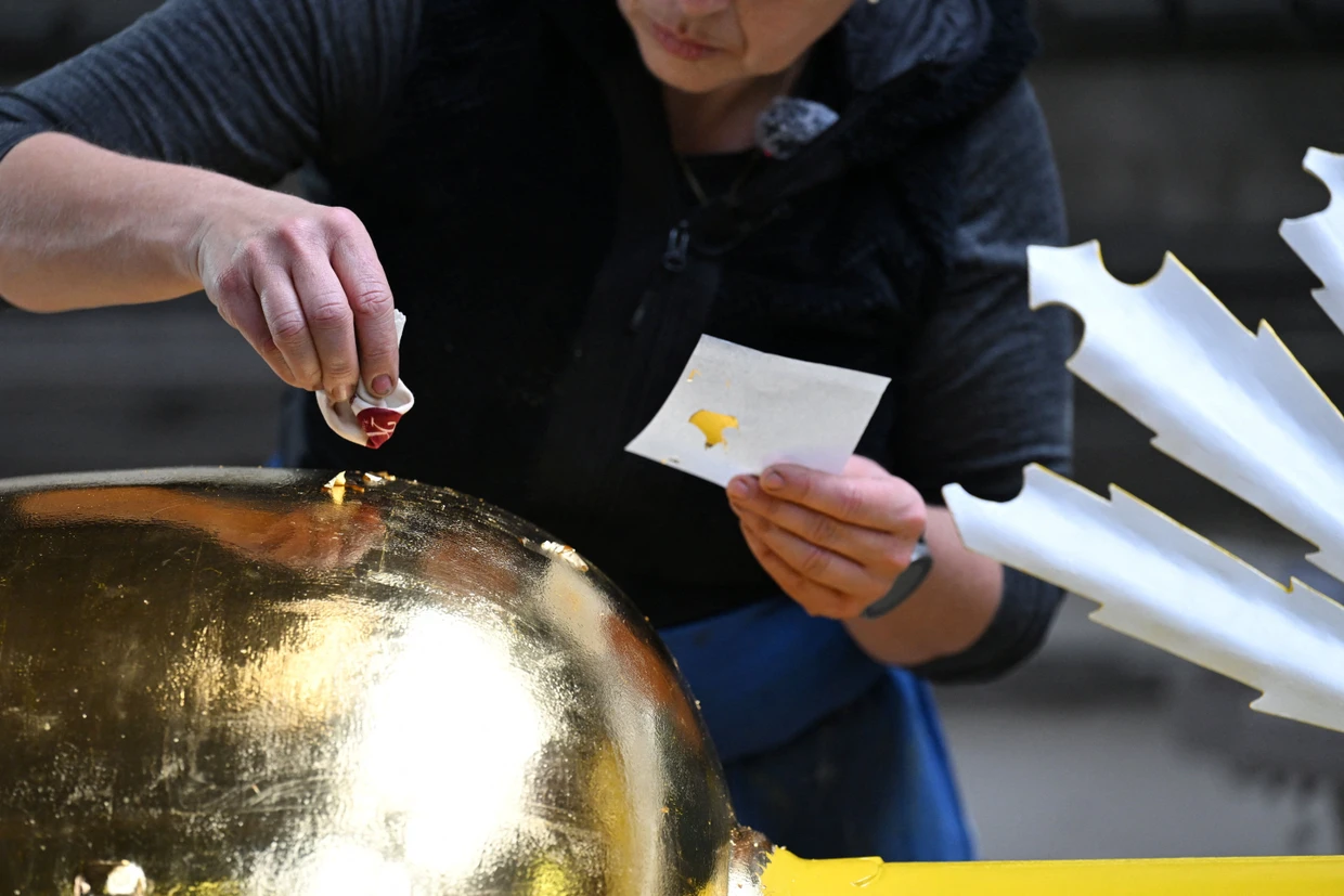Handarbeit: Kunstschmiedin Andrea Würzinger trägt neues Gold auf das Kreuz auf.