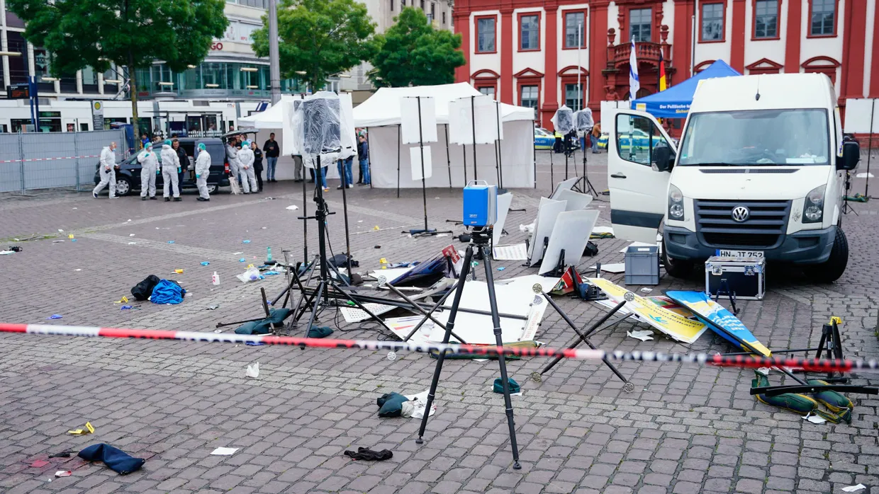 Mitarbeiter der Spurensicherung stehen am Freitag auf dem Mannheimer Marktplatz hinter einem zertrümmerten Stand.