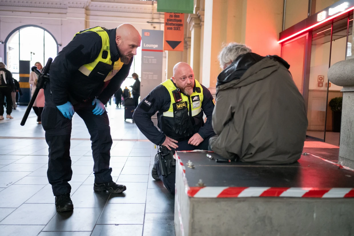 Sascha und Mario sprechen einen Mann in Bahnhof an.