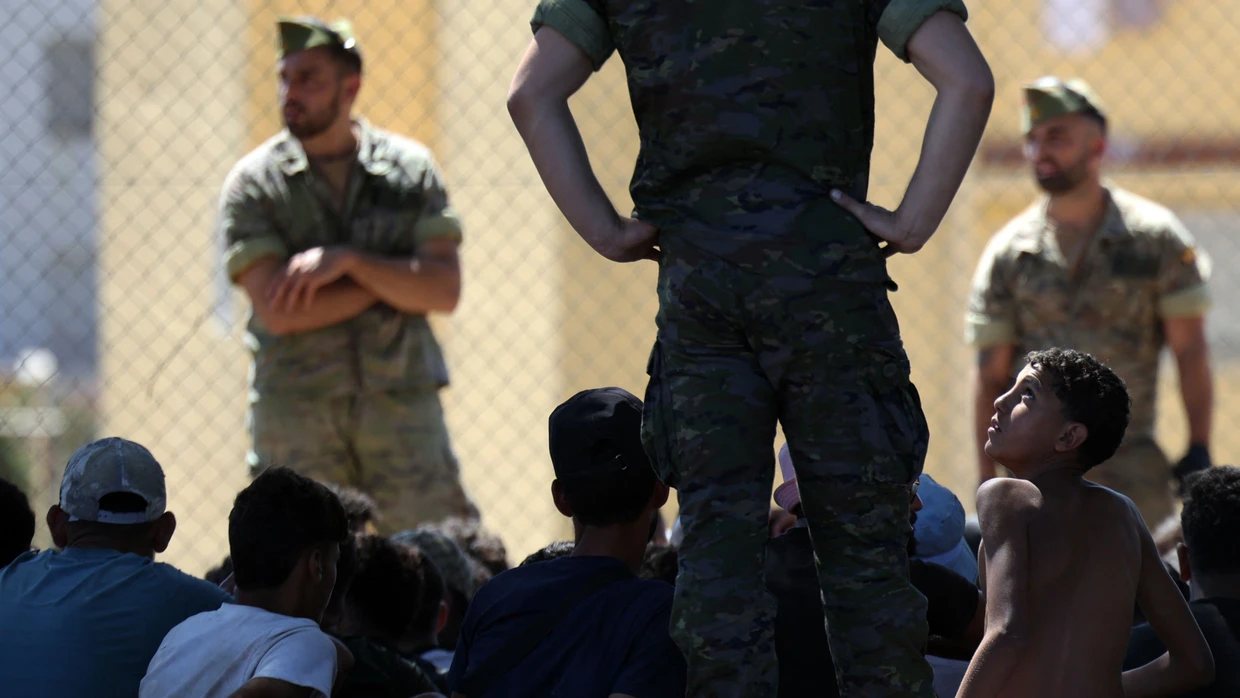 Spanische Soldaten stehen am 2. August bei einer Gruppe Migranten in Ceuta.