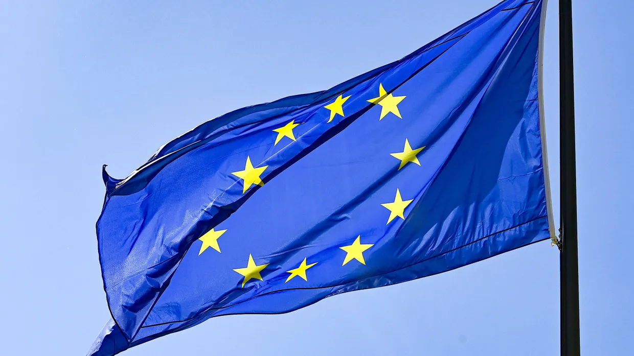 Eine Europaflagge weht vor blauem Himmel.
