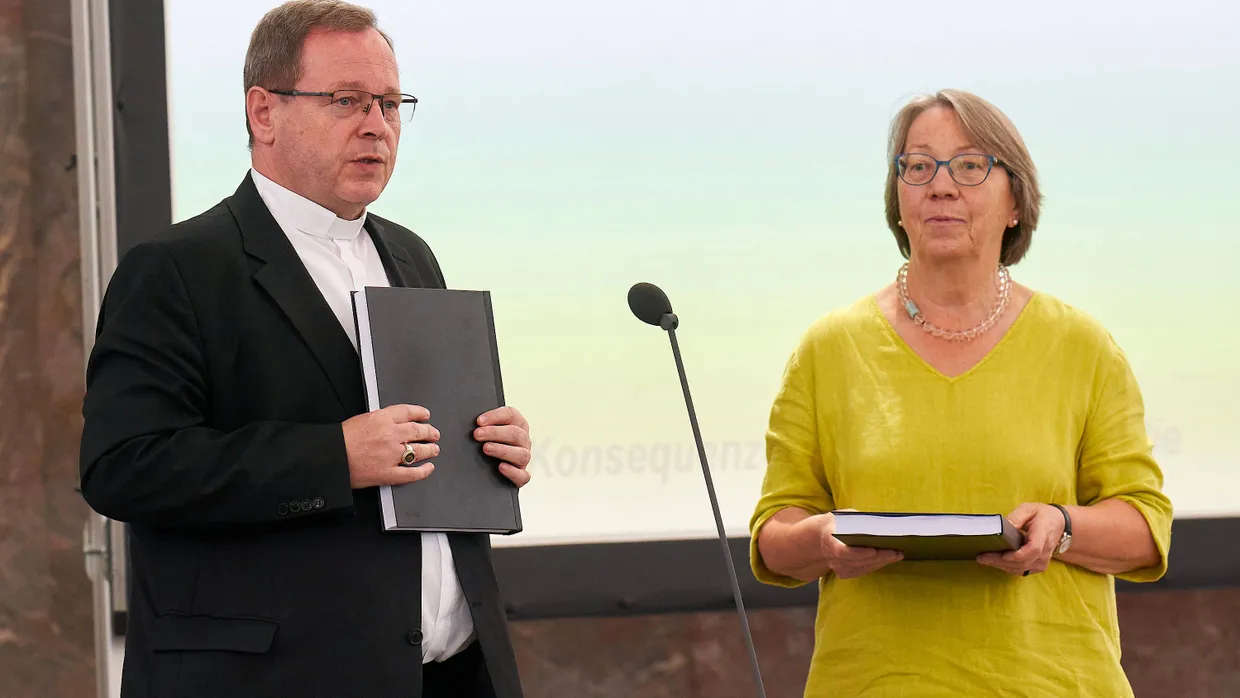 In der Frankfurter Paulskirche: Der Limburger Bischof Georg Bätzing hält den Bericht des Projekts „Betroffene hören - Missbrauch verhindern" in der Hand. Rechts neben ihm Ingeborg Schillai, die die Studie in Auftrag gegeben hatte.