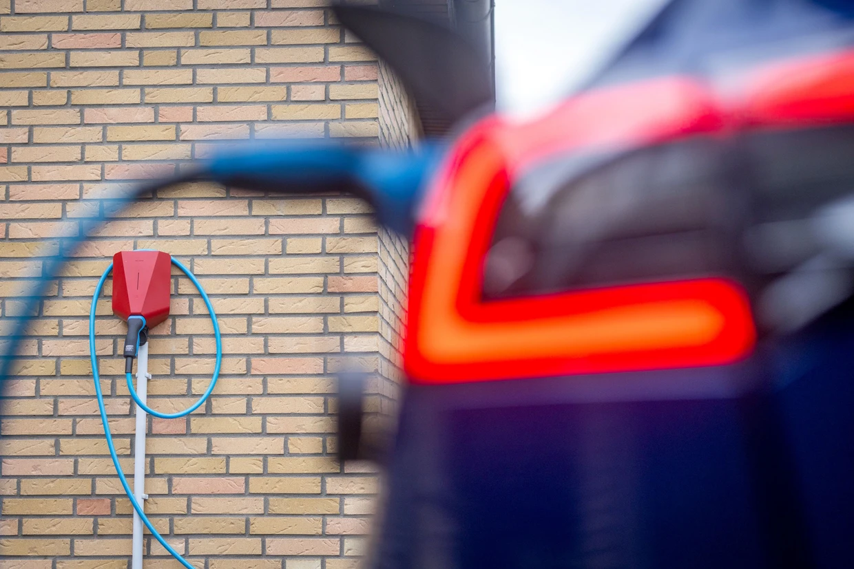 Se carga un coche eléctrico en una caja de pared de un edificio residencial.